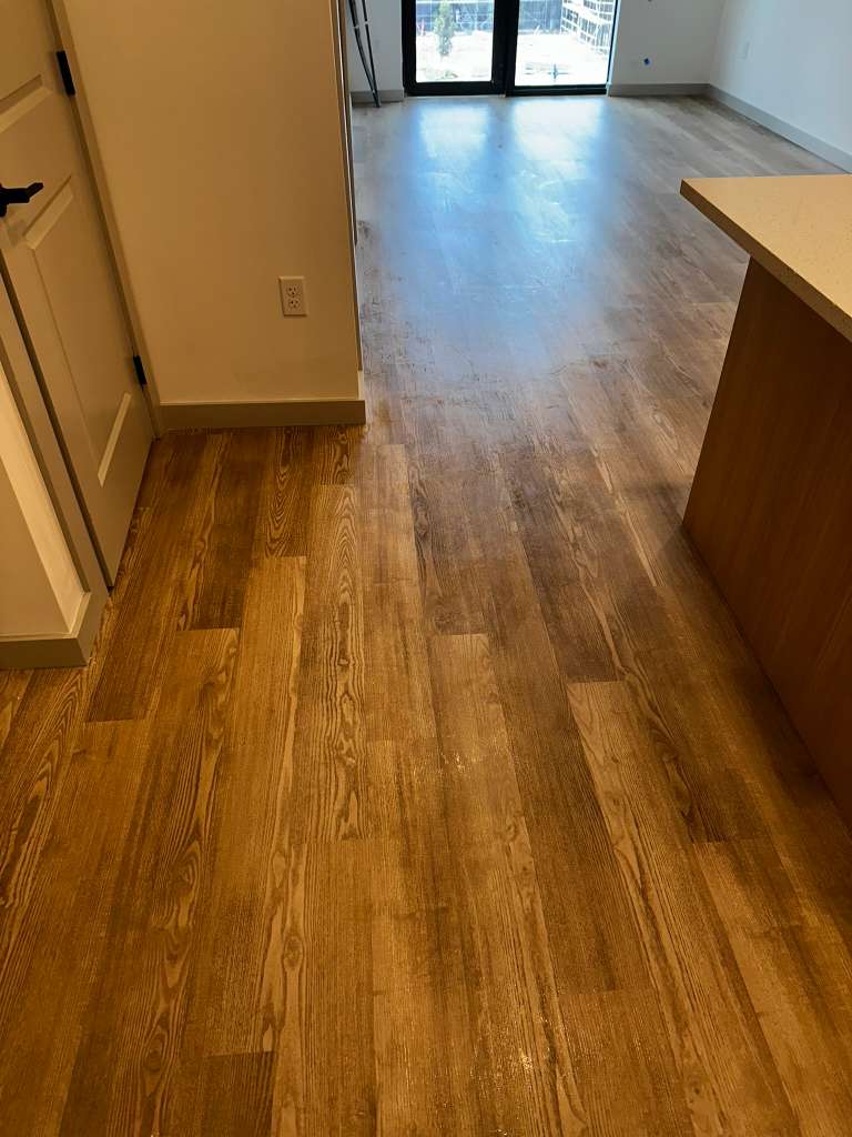 Freshly cleaned open-concept living and dining area with wood flooring in a Southwest Florida home
